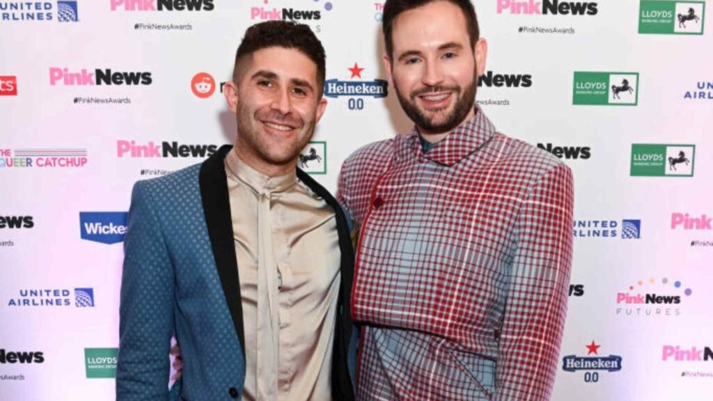 Benjamin Cohen and Anthony James of PinkNews standing together on a red carpet