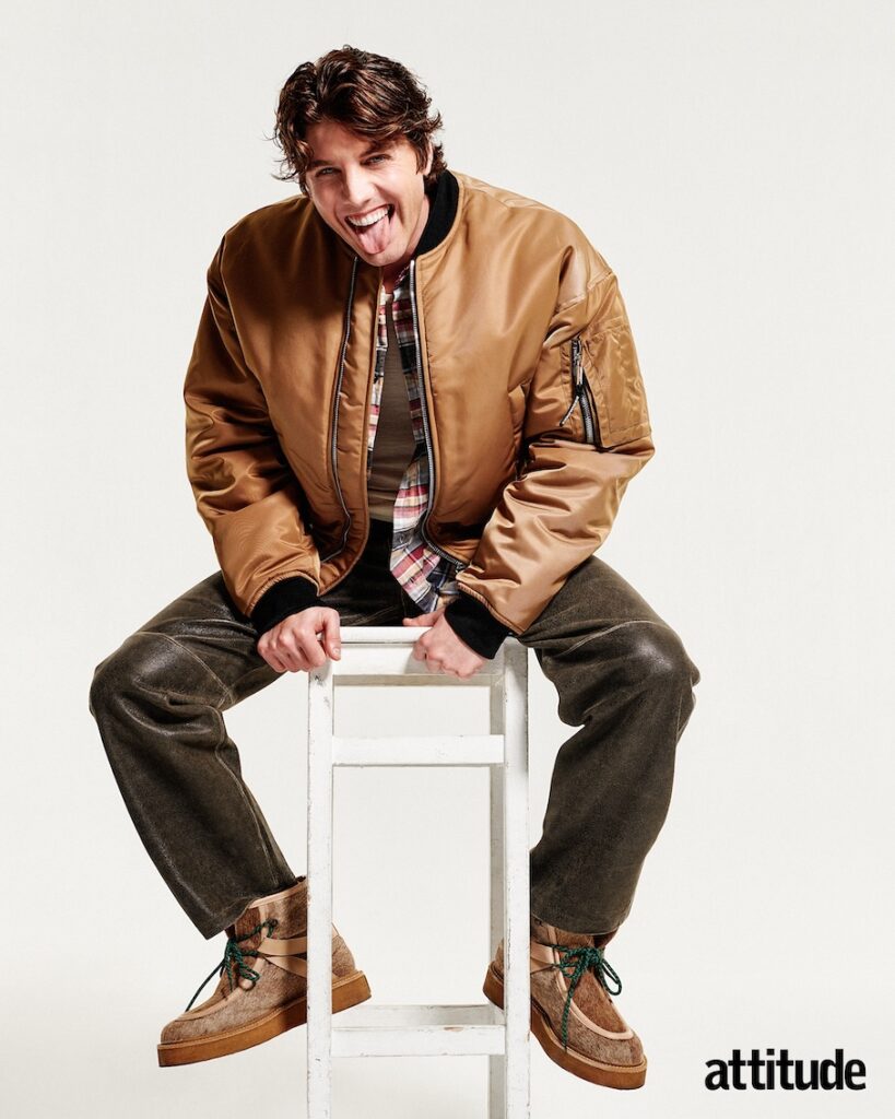 Lukas sitting on a stool in a tan jacket