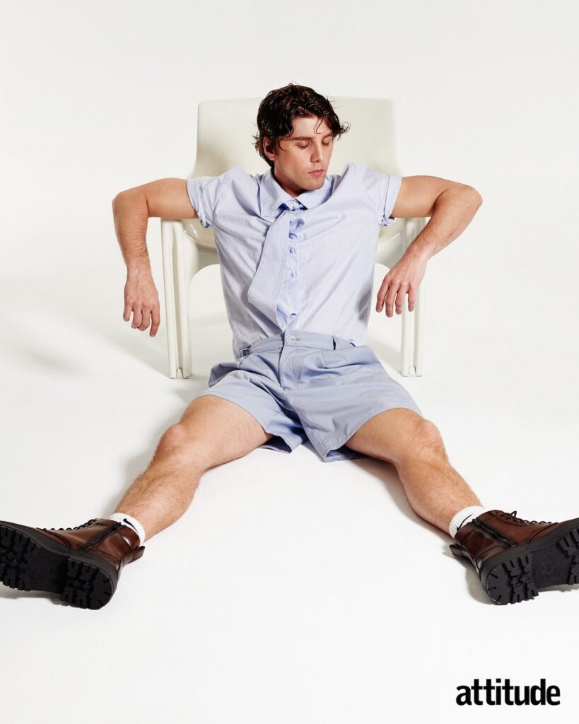 Lukas in a blue and white shirt and shorts combo sitting down