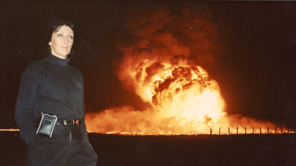 Margaret Moth stands in front of a large explosion