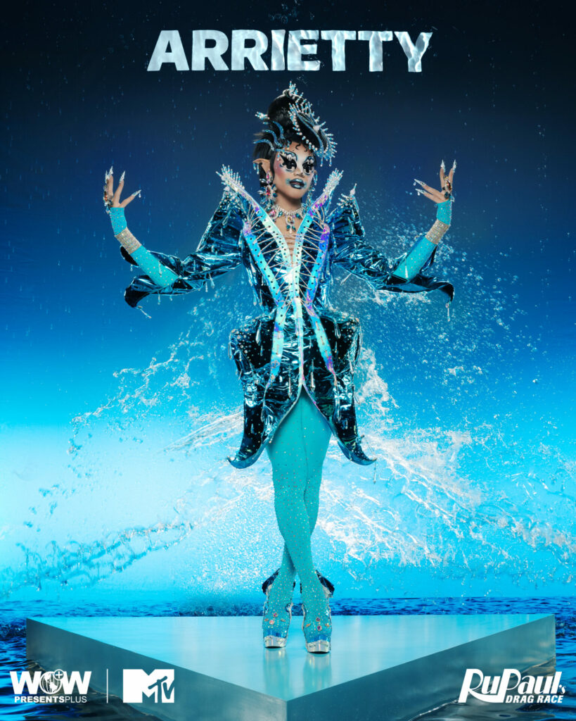 A drag queen against a water-themed blue backdrop