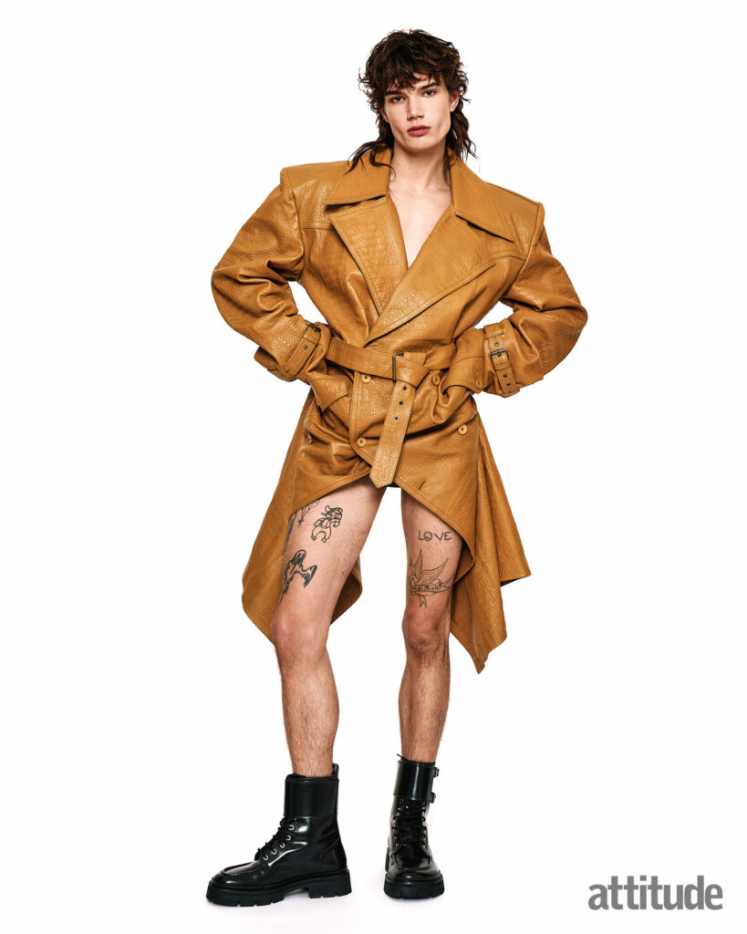 Model poses in brown trench coat and black boots