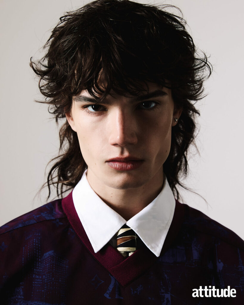 Close up shot of model wearing shirt, vintage tie, and printed v neck jumper