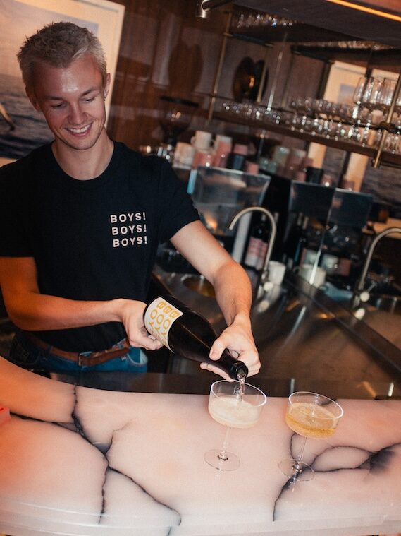 a guy pouring a drink on the marble-top bar