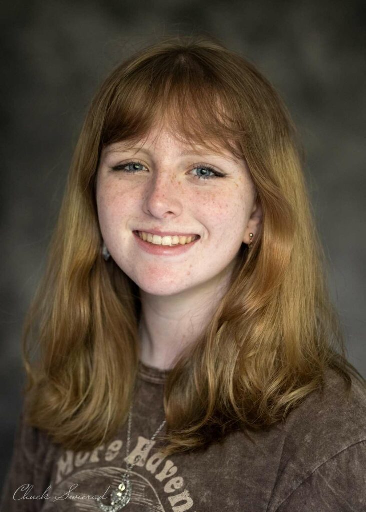 A smiling person with auburn hair