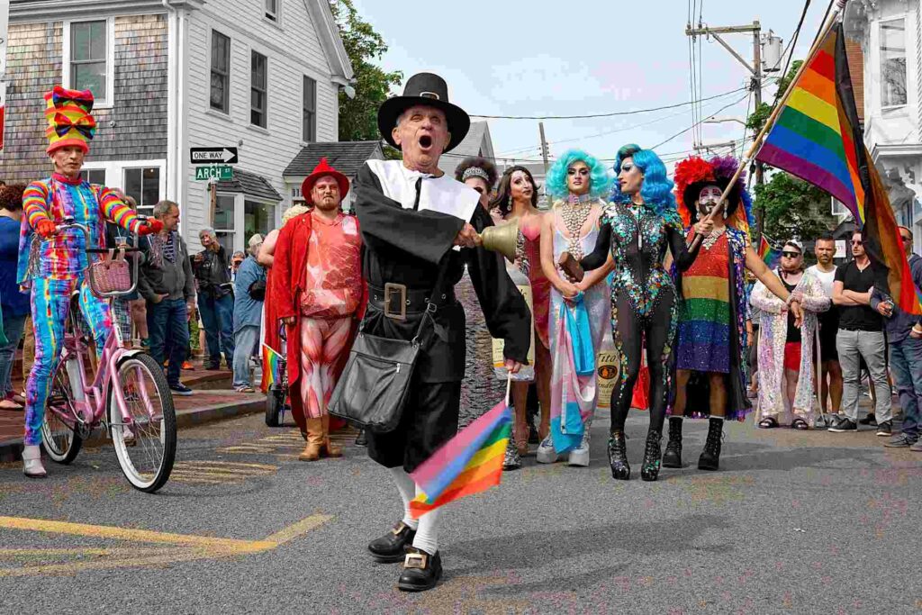 A group of drag queens and a person dressed as a pilgram in the streets of Provincetown