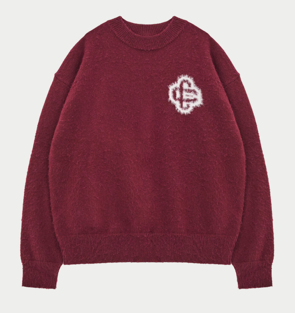 Burgundy fluffy sweatshirt with emblem detail on top right