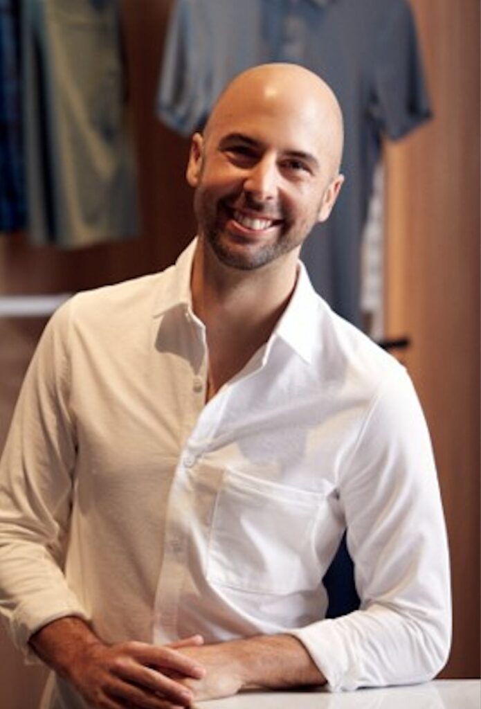 A smiling man wearing a white shirt