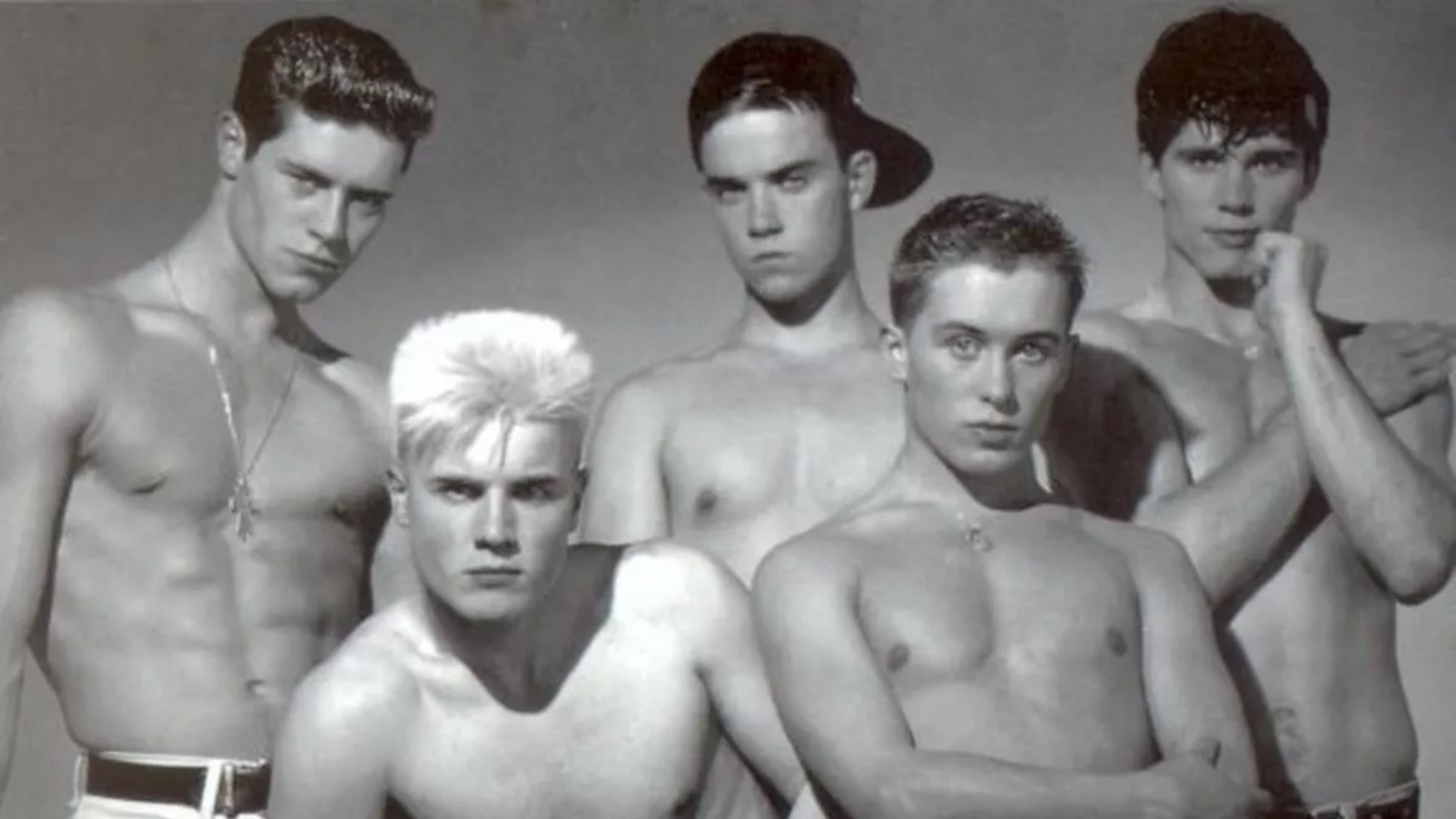 A black and white topless shot of the five original members of Take That