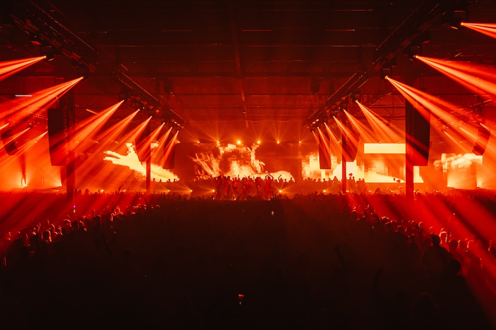 a logn shot of the big room at the venue with orange lights