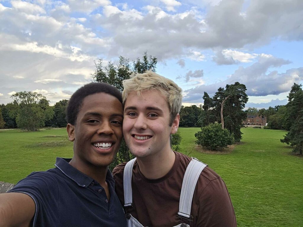 A smiling couple pose together in a green field