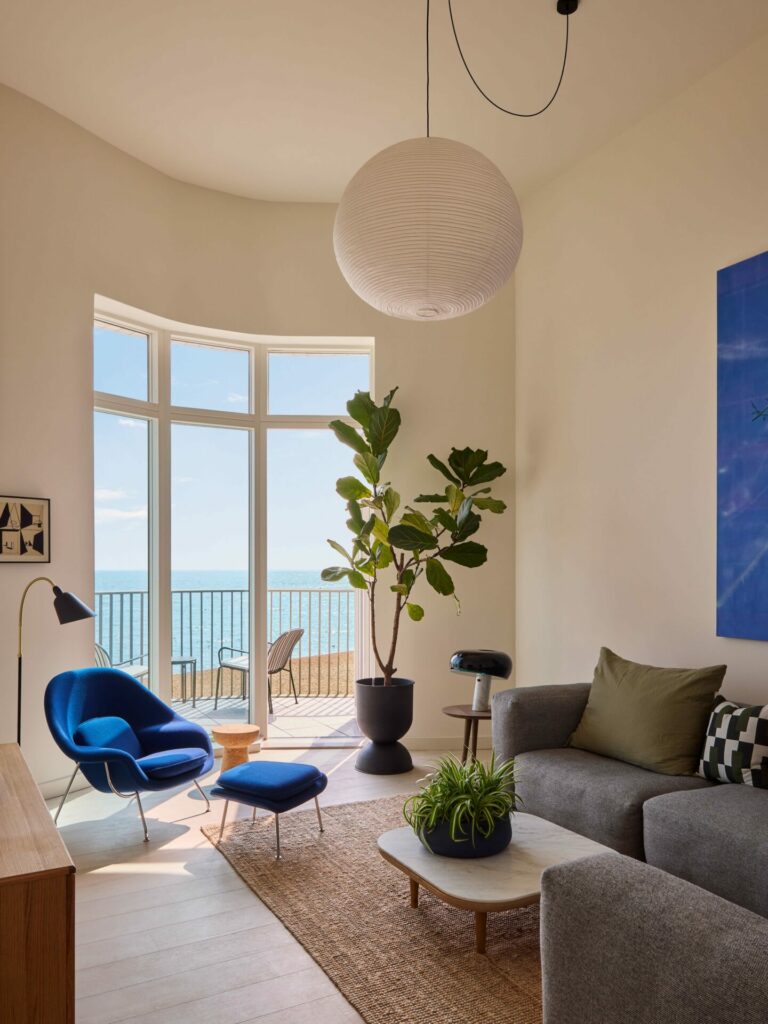 View of a living room with a large bay window overlooking the ocean