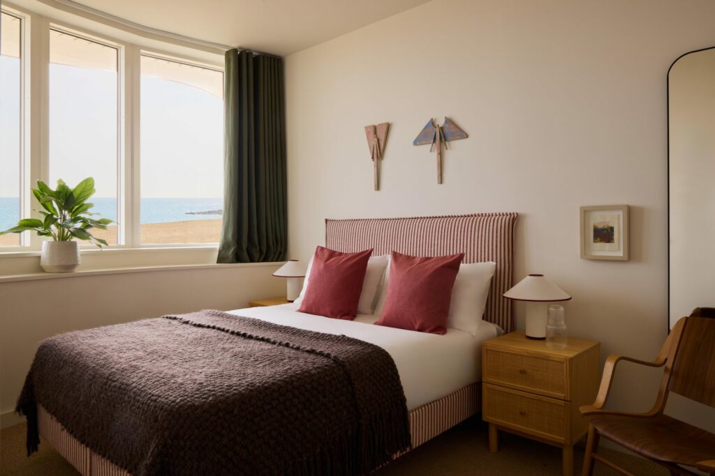 View of a bedroom with a large bed with a  view of the ocean through the window