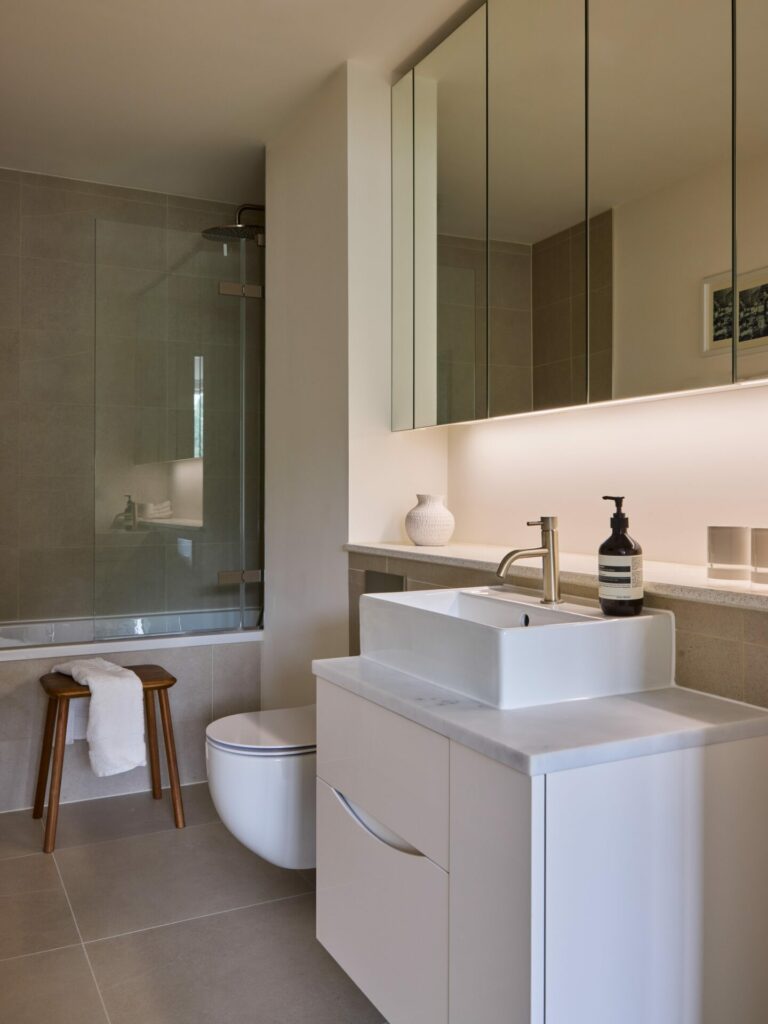 View of a modern bathroom with a white basin and large mirror