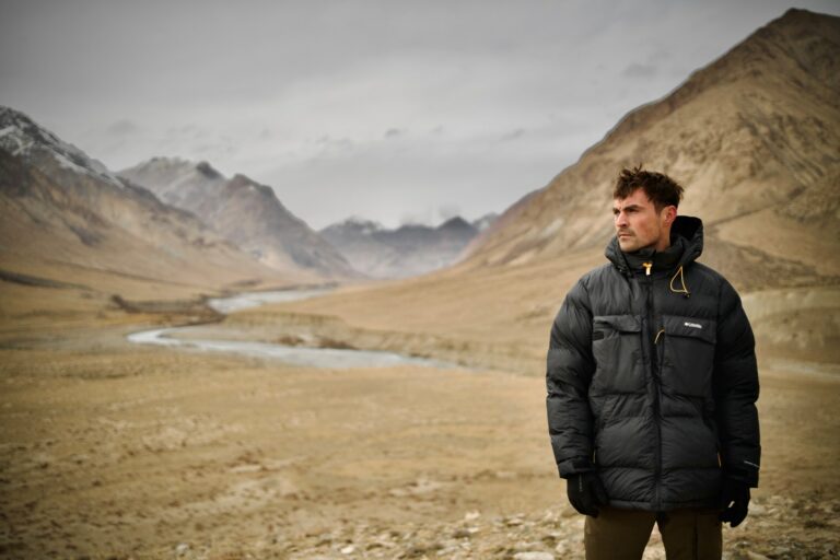 Dan O'Neill standing in in the Gobi Desert wearing a black coat