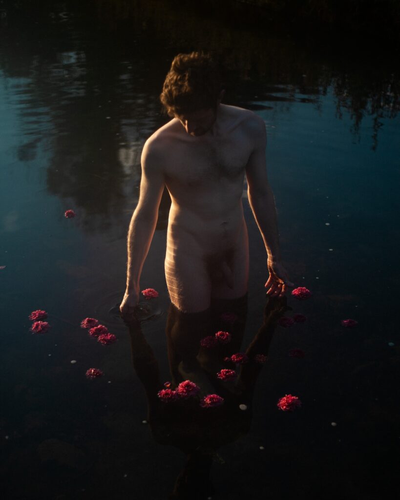 a man standing in water, naked