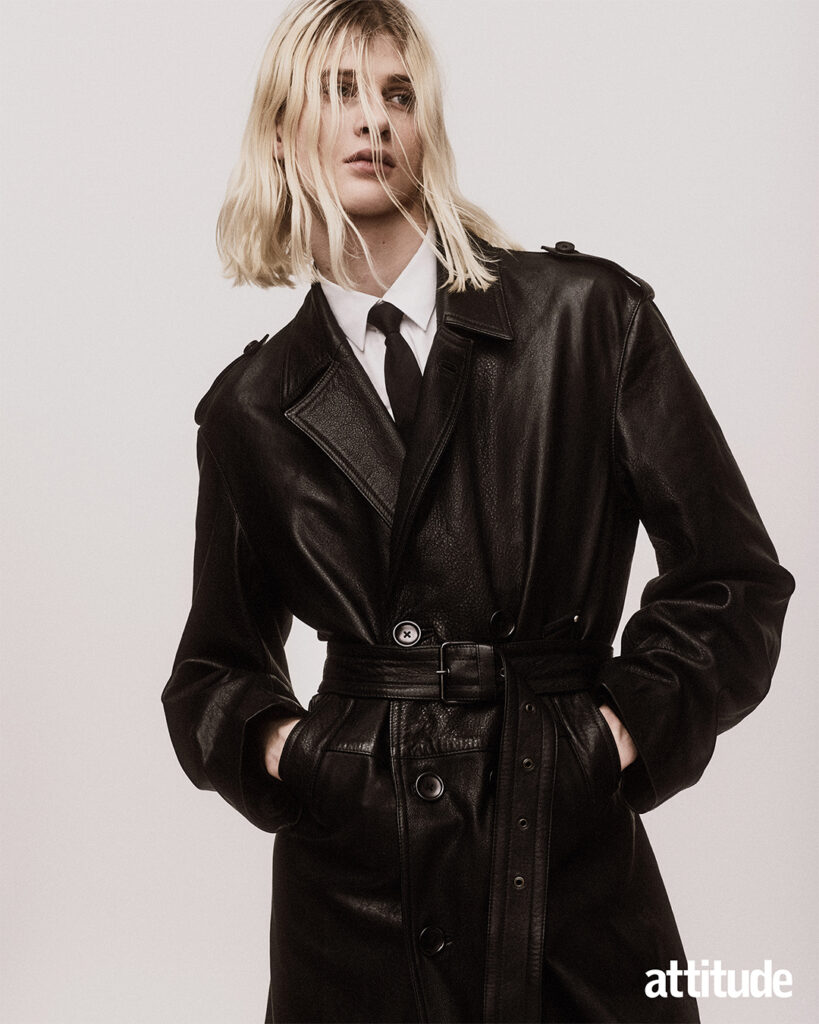 Close up shot of model wearing leather trench coat, white shirt and black tie