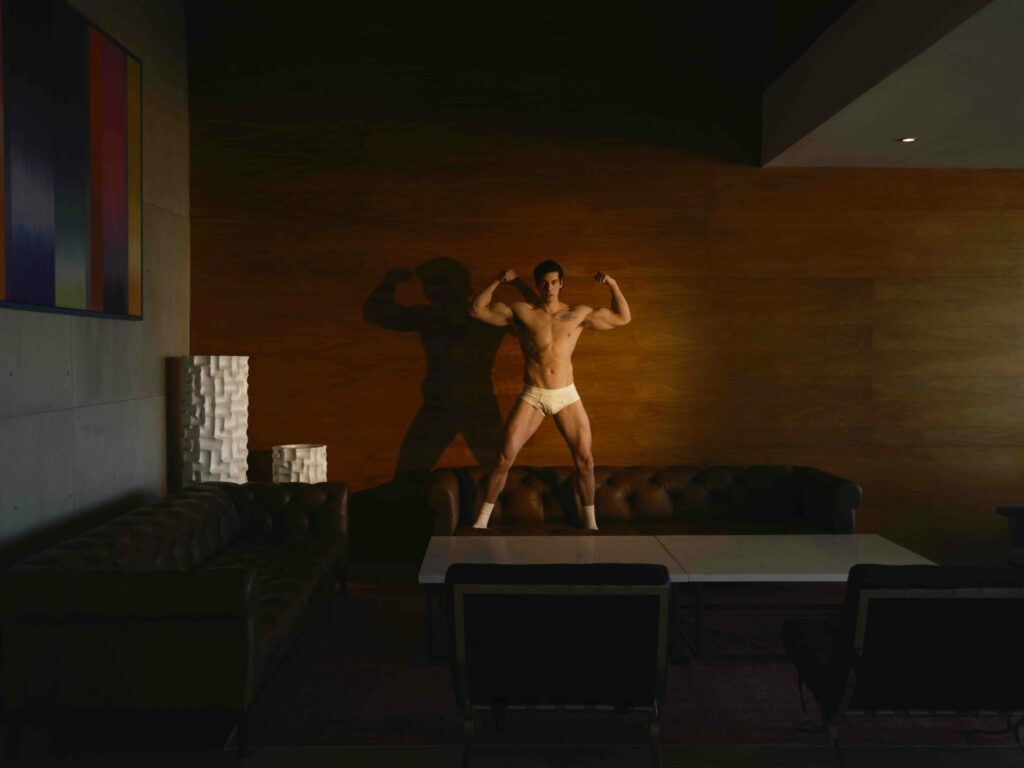 a man standing on a sofa in white underwear