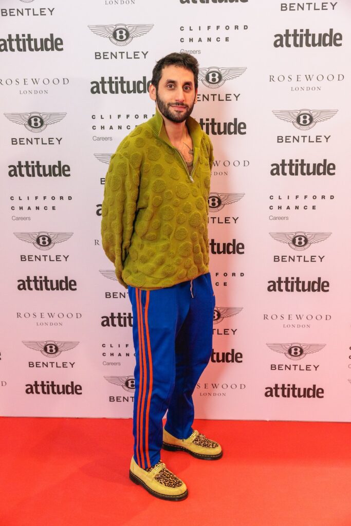 Amrou in a green top and blue trousers