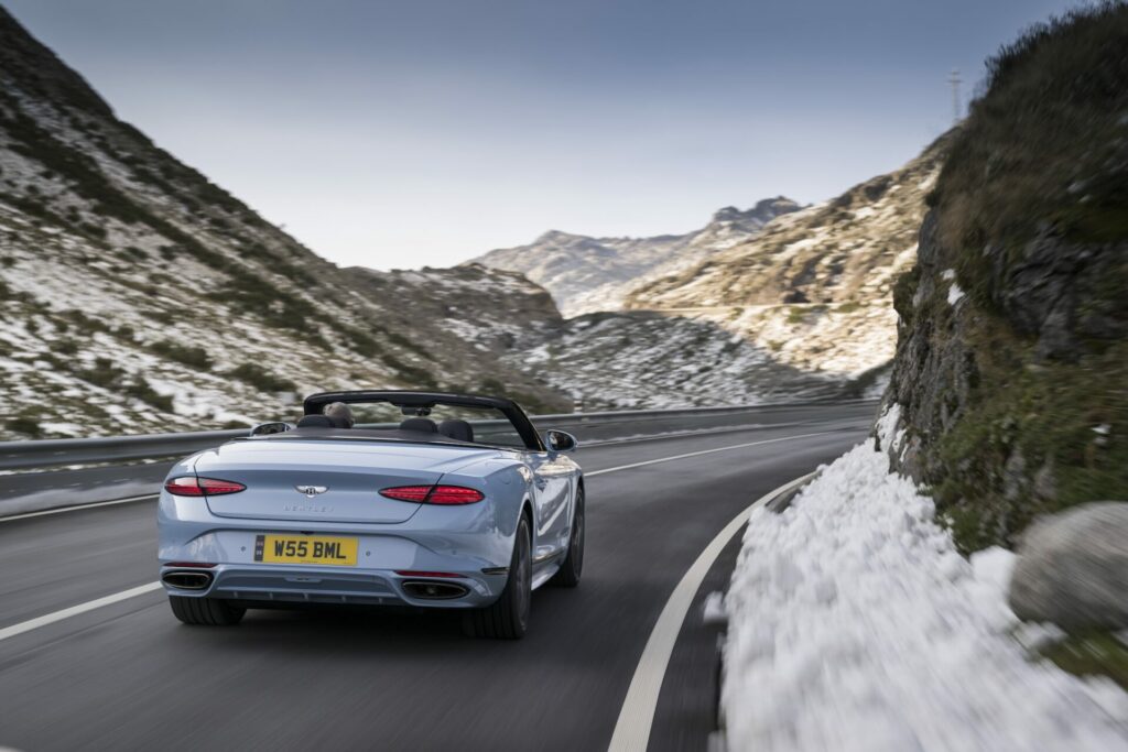 the car shot from behind surrounded by mountains 