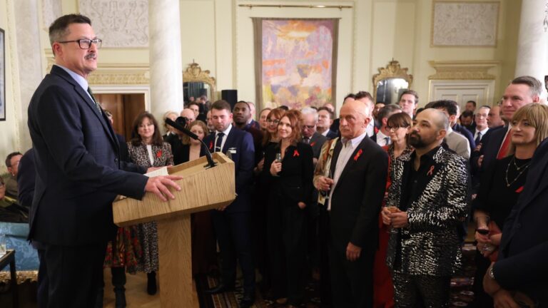 Robbie on a podium speaking at 10 Downing Street on World AIDS Day 2024