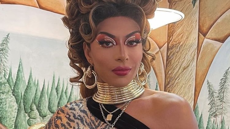 Close crop of Shangela wearing a gold ring necklace and leopard print top