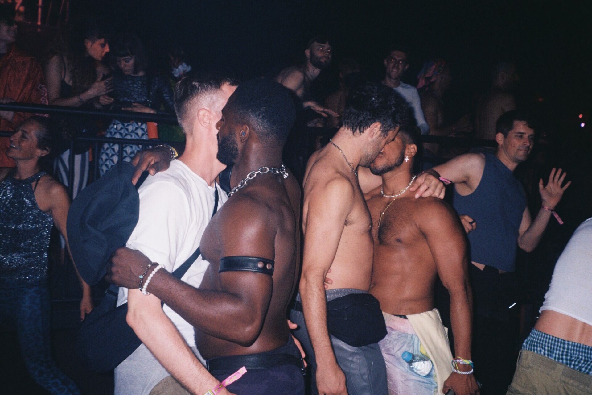 two pairs of people kissing on a dancefloor