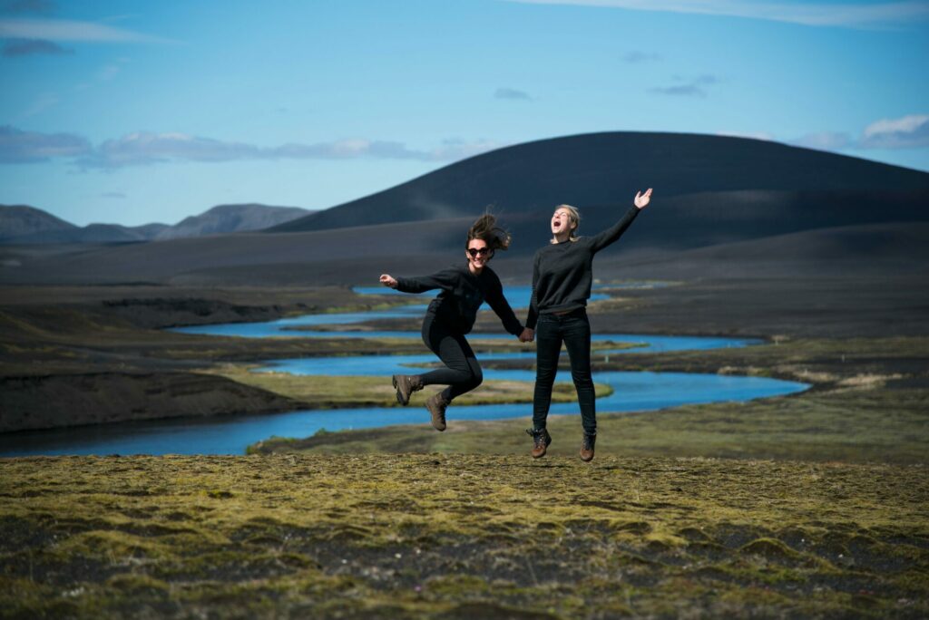 Two women jumping with excitement in the Iceland countryside